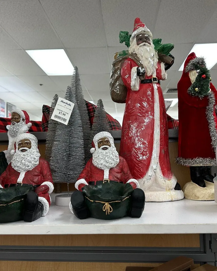 Black Santa Claus figurines and a silver tinsel tree displayed on a store shelf.